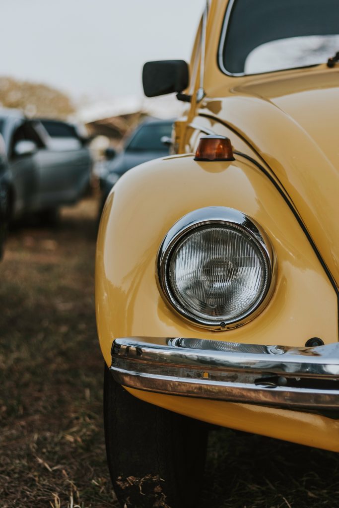 Front headlight of yellow Volkswagen Beetle