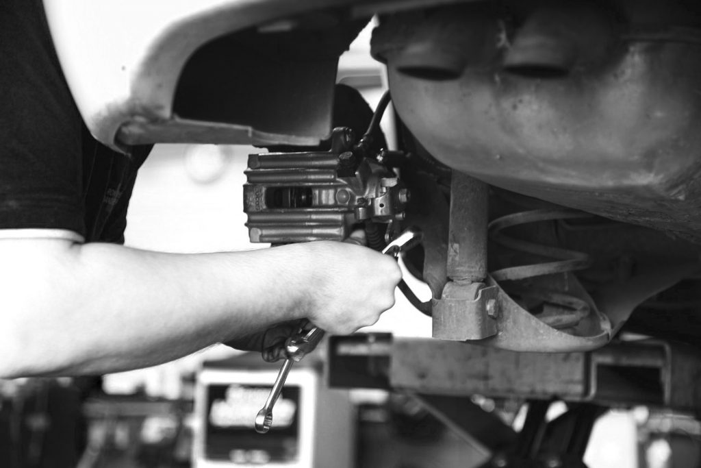 Mechanic repairing vehicle brakes